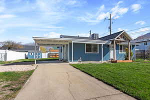 View of front facade featuring driveway, an attached carport, and roof with shingles