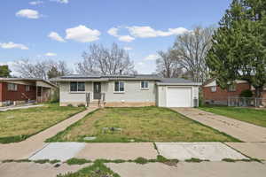 Ranch-style home featuring brick siding, driveway, a garage, and solar panels