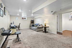 Exercise room with a textured wall, carpet flooring, and a textured ceiling