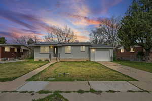 Ranch-style house with brick siding, concrete driveway, a garage, and solar panels