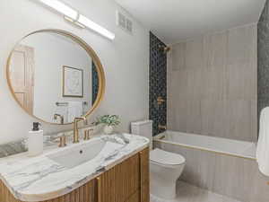 Bathroom with vanity and tiled shower / bath combo