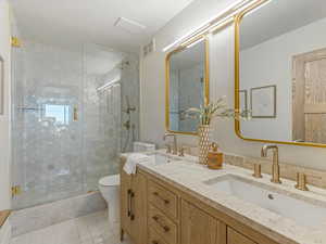 Bathroom featuring double vanity and a shower stall