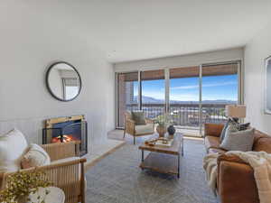 Living area with a mountain view, a fireplace, wainscoting, plenty of natural light, and wood finished floors