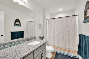 Bathroom with vanity, a shower with curtain, light wood finished floors, and recessed lighting