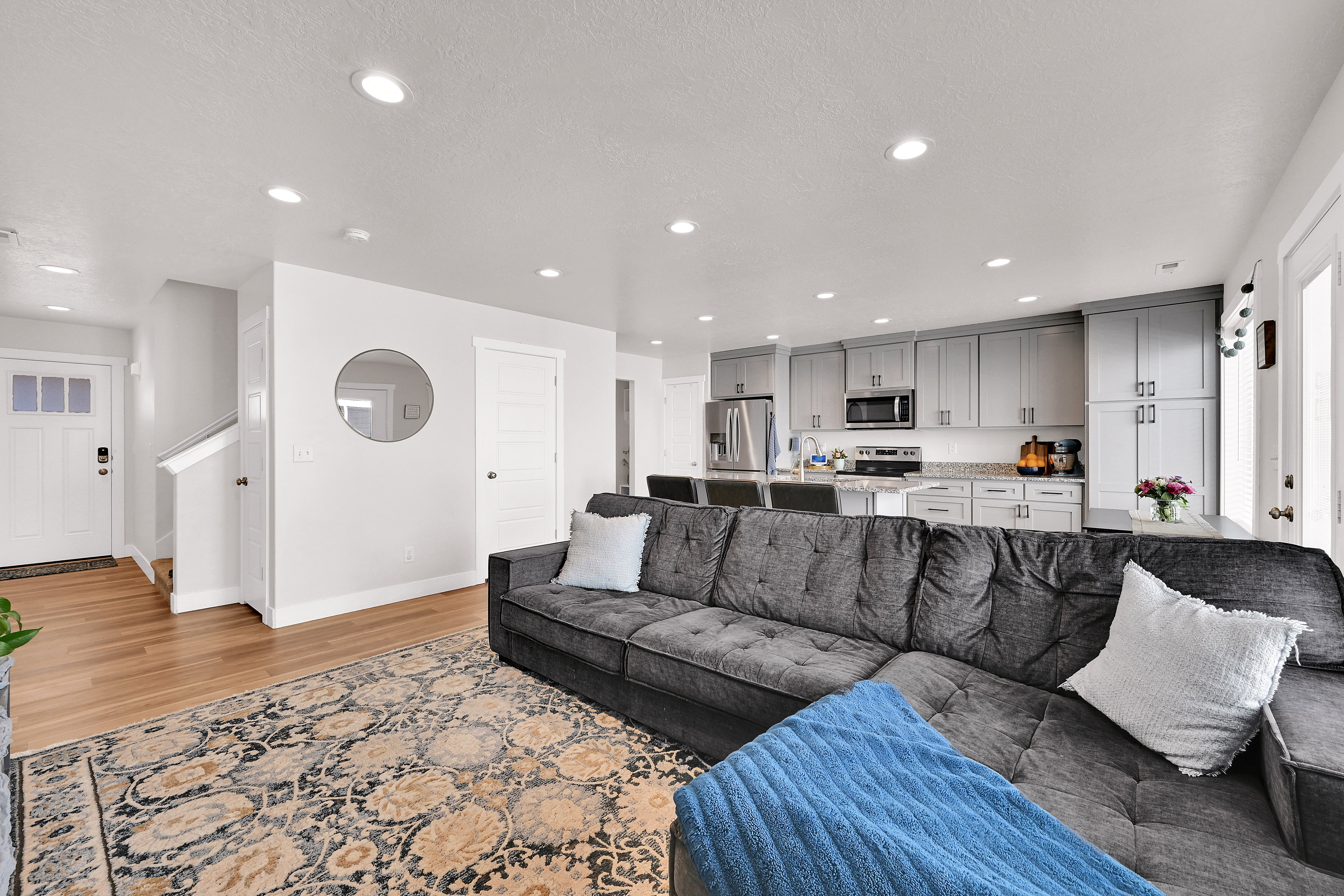 Living area with light wood-type flooring and recessed lighting