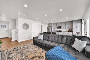 Living area with light wood-type flooring and recessed lighting