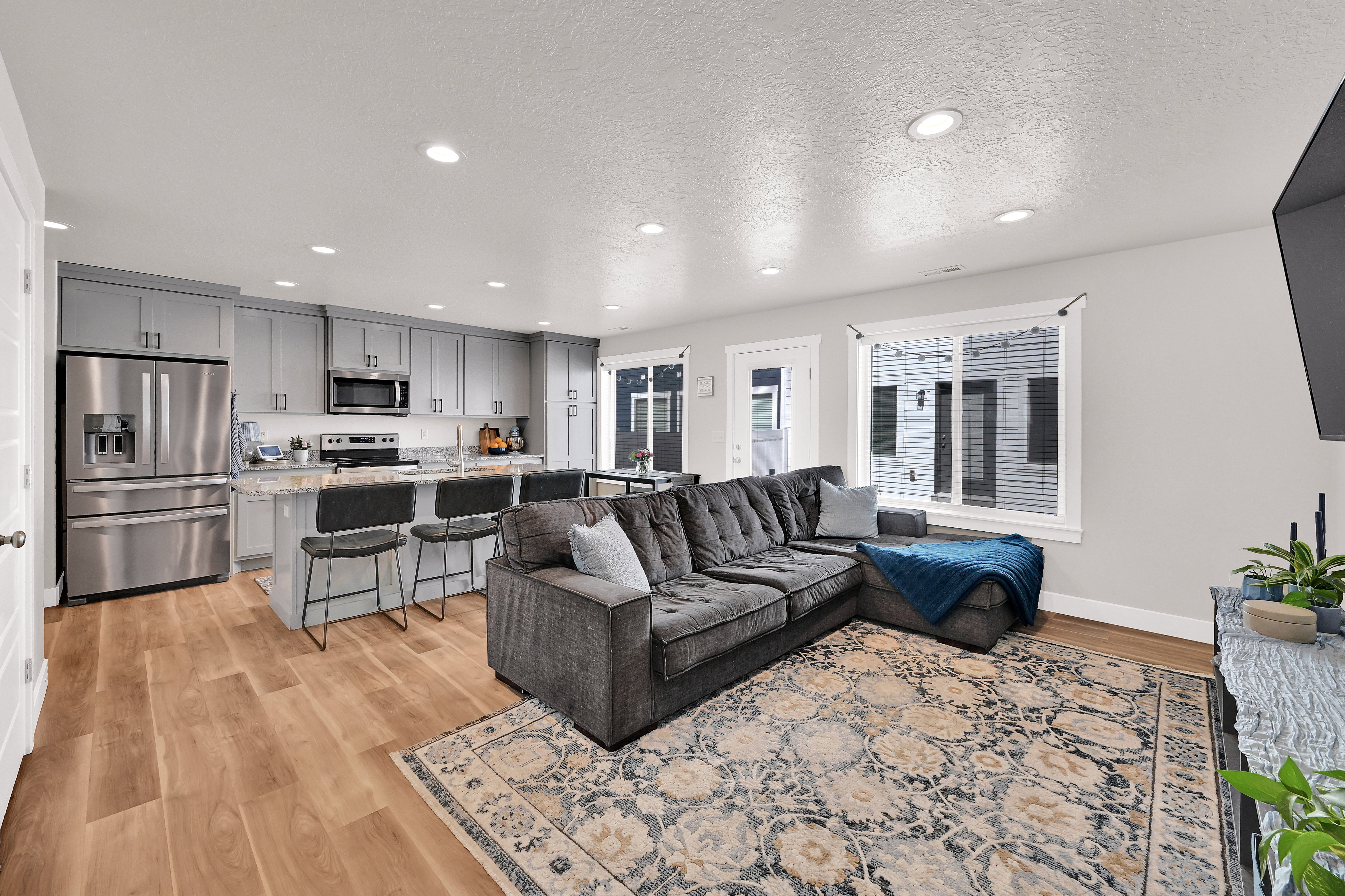 Living area with a textured ceiling, light wood-style floors, and recessed lighting