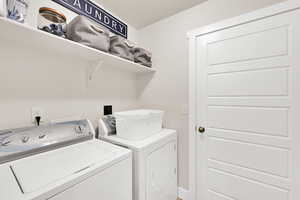 Laundry room featuring washer and dryer and baseboards