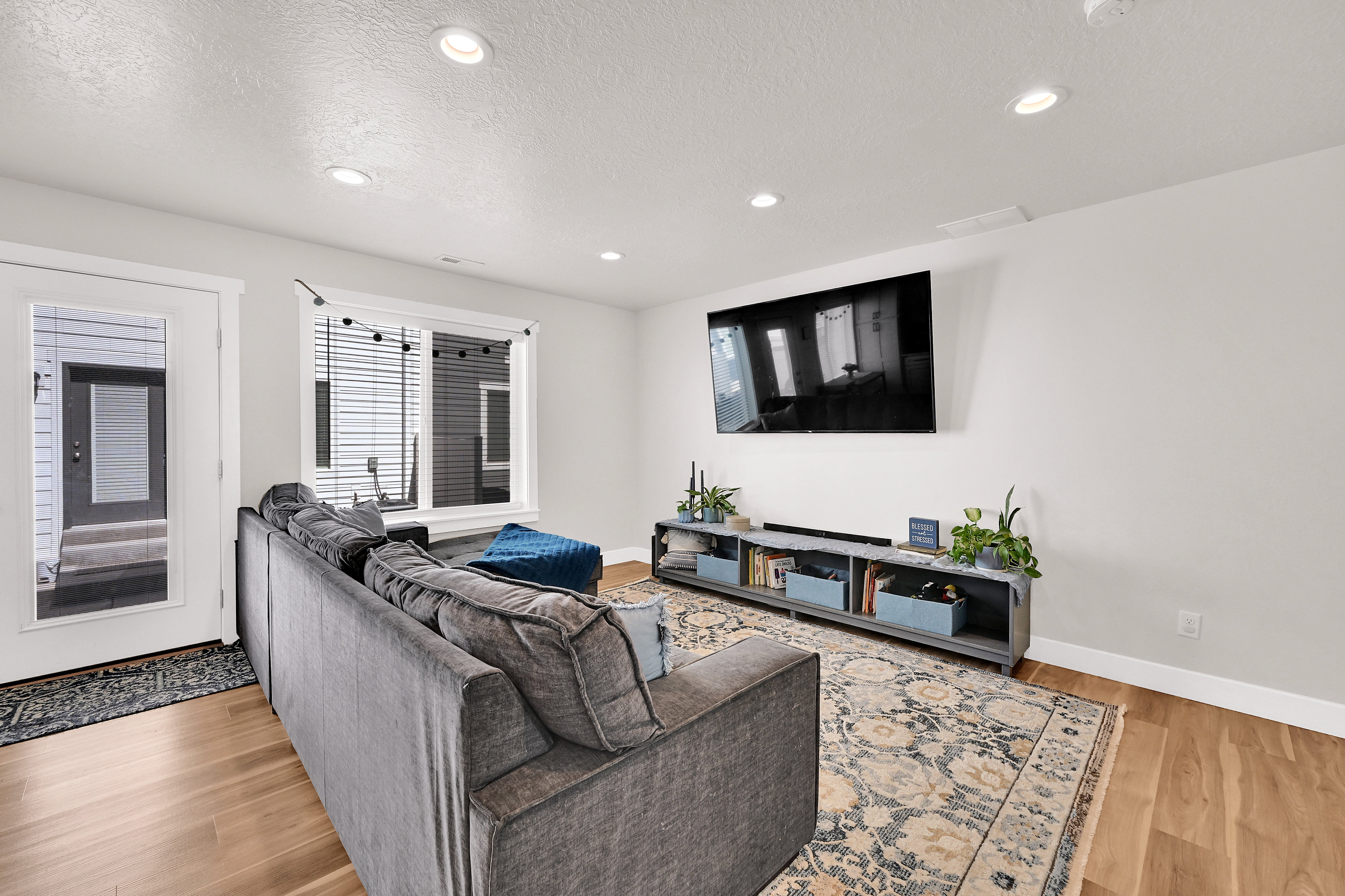 Living area with light wood-style floors, recessed lighting, and a textured ceiling