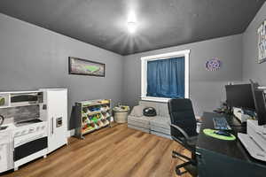 Home office with wood finished floors and baseboards