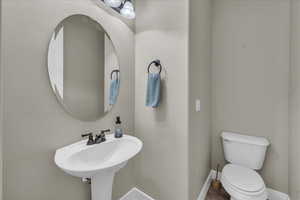 Half bath with toilet and baseboards