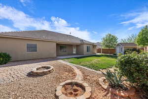 Back of house with a fire pit, a patio area, a shed, stucco siding, and a fenced backyard
