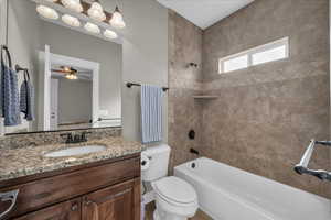 Bathroom featuring vanity, shower / tub combination, and ceiling fan