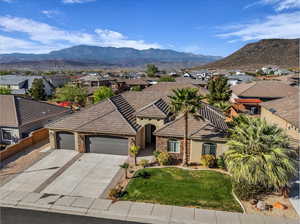 View of front of property featuring an attached garage, stone siding, stucco siding, and a residential view