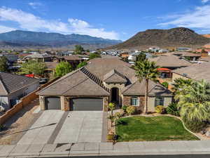 View of front facade with stucco siding, a garage, stone siding, and concrete driveway