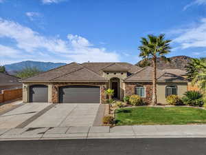 View of front of property with a garage, stucco siding, stone siding, and driveway