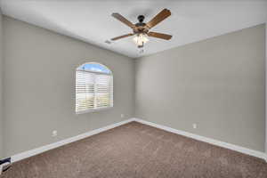 Carpeted empty room with baseboards and ceiling fan