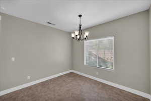 Spare room with suspended lighting and baseboards