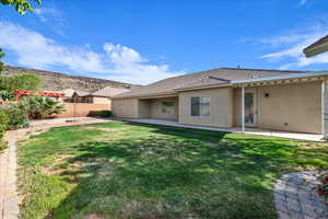 Back of property with stucco siding, a patio, and a tiled roof