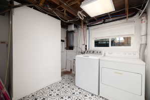 Laundry area with washer and clothes dryer and electric panel