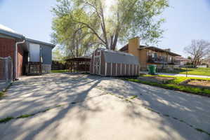 View of side of home with a storage unit and brick siding