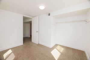 Unfurnished room featuring baseboards and light colored carpet