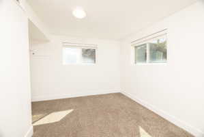 Carpeted empty room featuring baseboards