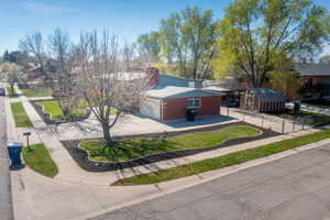 View of front of house featuring a storage shed, concrete driveway, and brick siding
