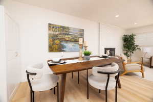 Office area featuring light wood-style flooring, a brick fireplace, and recessed lighting