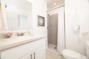 Bathroom with vanity, a shower stall, light tile patterned floors, and recessed lighting