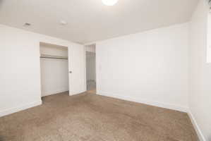 Unfurnished bedroom with a closet and carpet floors