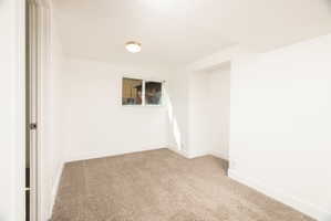 Spare room featuring baseboards and light colored carpet