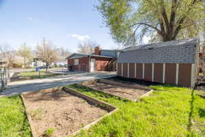 View of yard featuring concrete driveway and an outbuilding