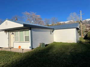 View of home's exterior with a lawn and a metal roof