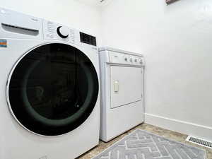 Laundry room with baseboards and washing machine and clothes dryer