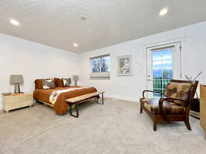 Bedroom with a textured ceiling, light carpet, access to outside, and recessed lighting