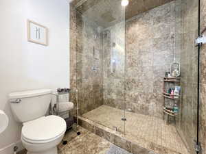 Bathroom featuring toilet and a stall shower