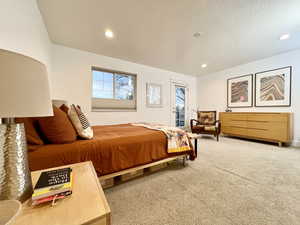 Bedroom featuring access to exterior, a textured ceiling, light carpet, and recessed lighting