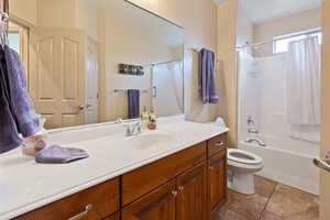 Full bath featuring vanity, shower / tub combo, and light tile patterned floors