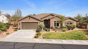 Ranch-style house with stone siding, stucco siding, a garage, and driveway