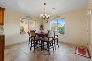 Dining space featuring hanging lights, healthy amount of natural light, and light tile patterned floors
