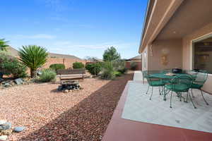 Fenced backyard with a patio area, outdoor dining area, and an outdoor fire pit