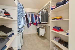 Walk in closet featuring light colored carpet