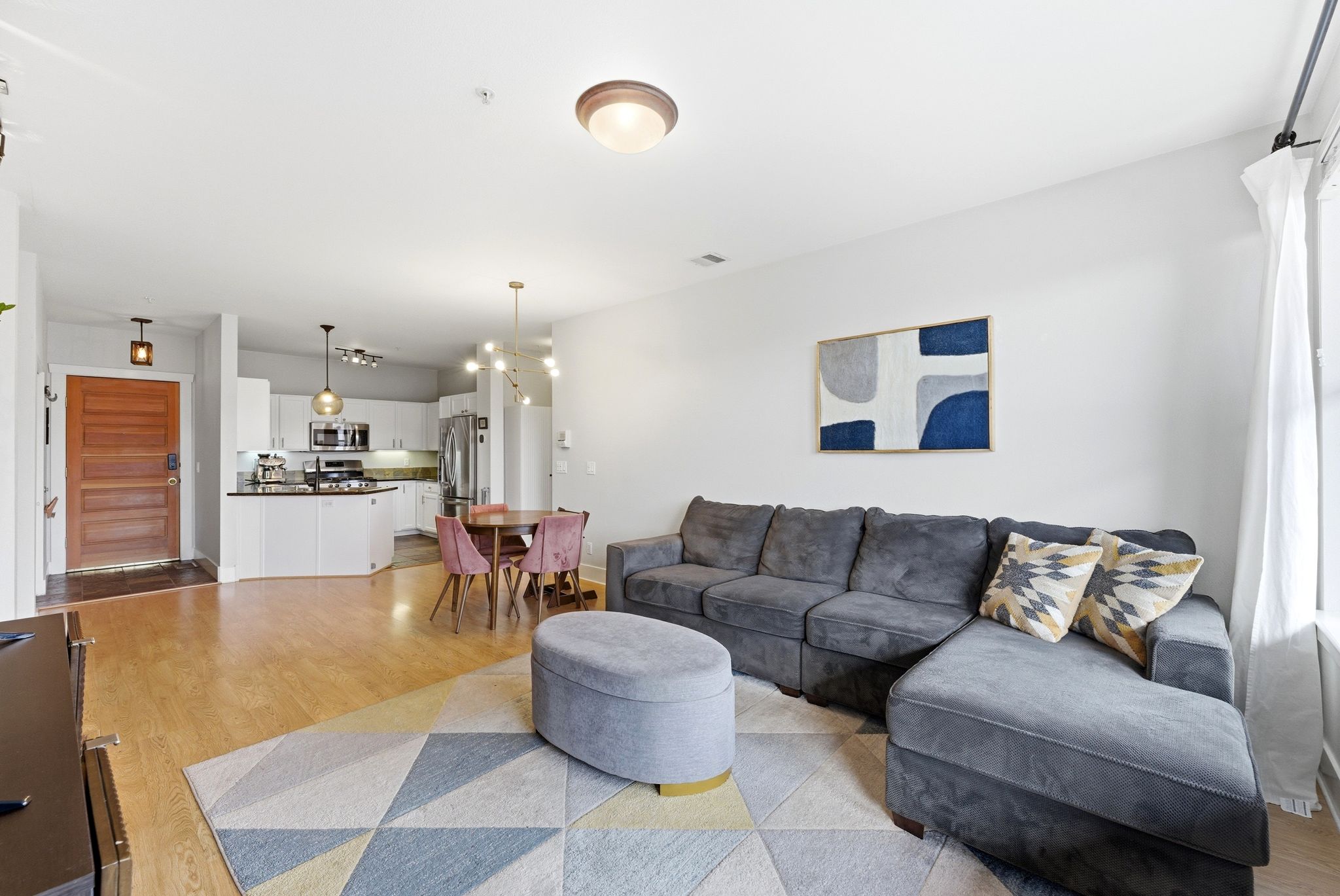 Living room with light wood-style flooring and a chandelier