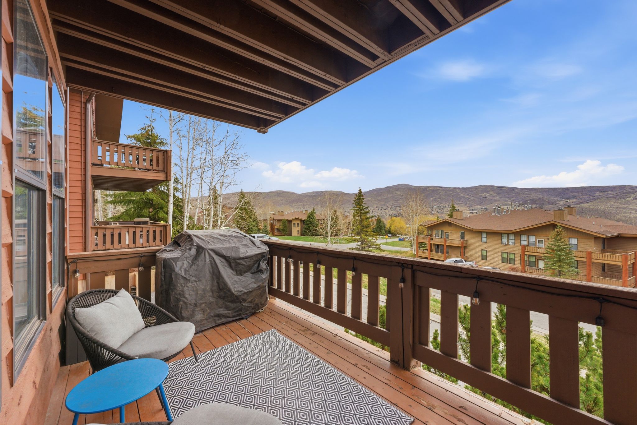 Deck with a grill, a mountain view, and a residential view