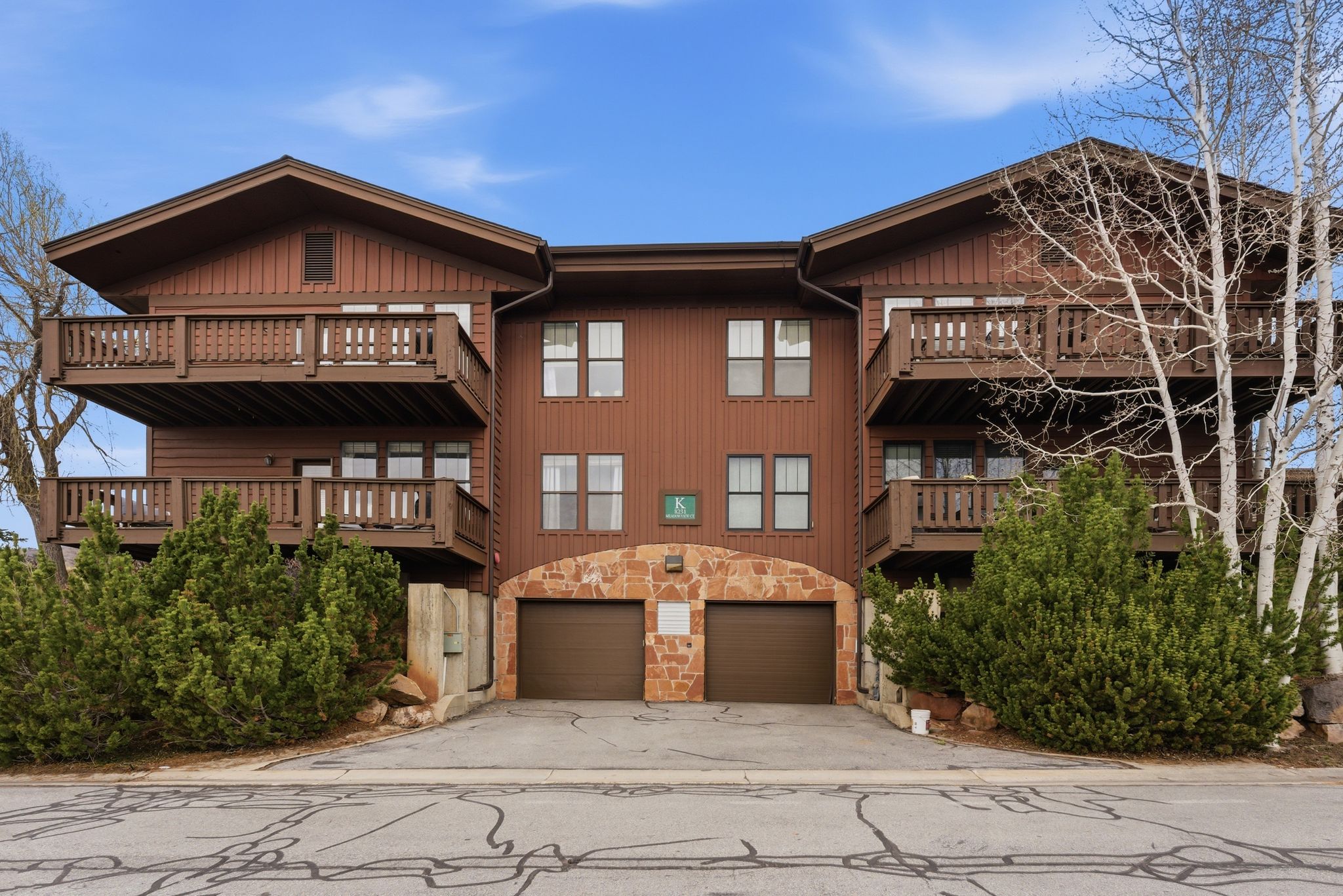 View of apartment building / complex with a garage and driveway