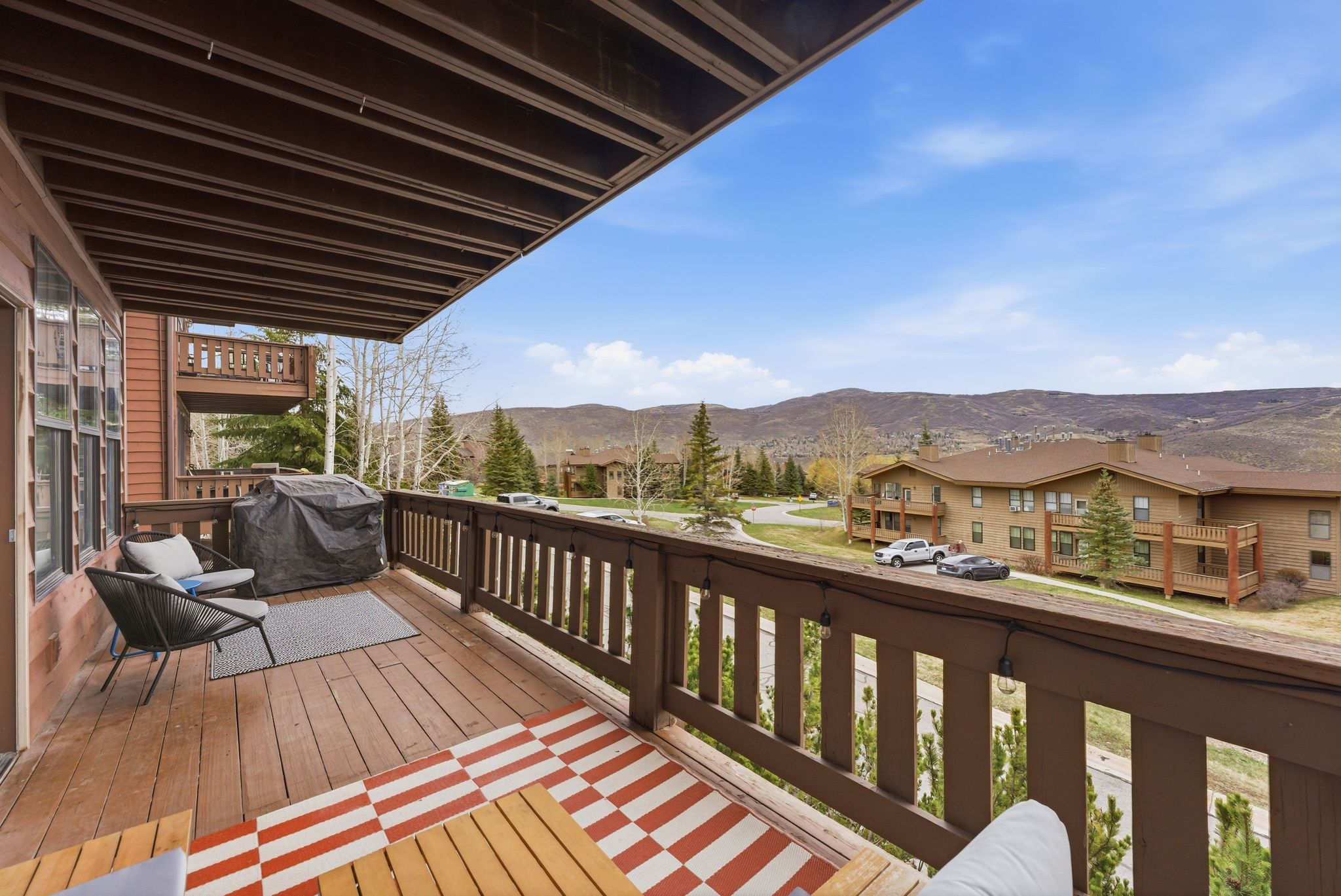 Wooden terrace featuring a mountain view, a grill, and a residential view