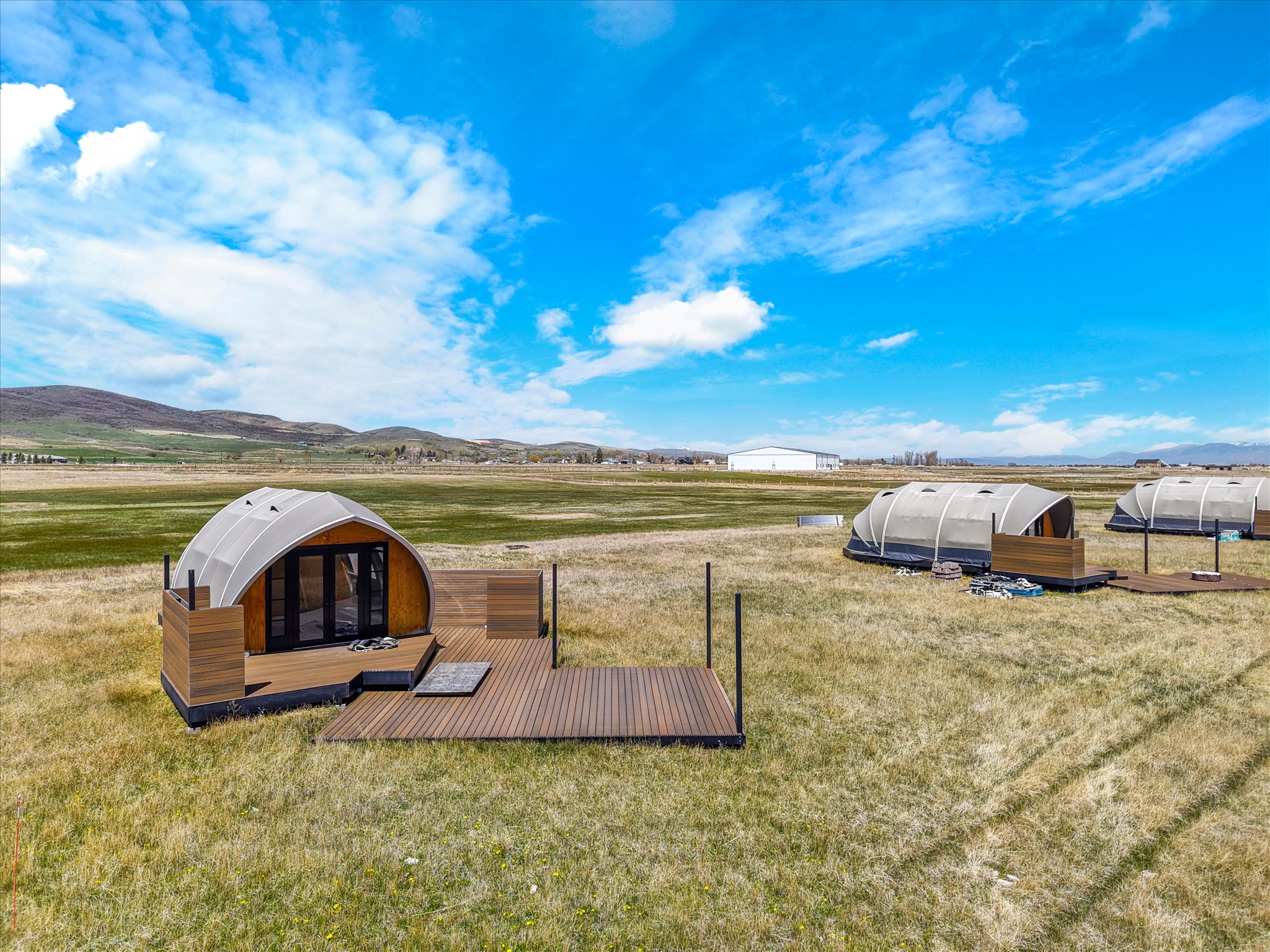 View of green lawn with a view of rural / pastoral area, a deck with mountain view, and an outbuilding