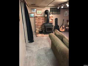 Carpeted living room featuring a wood stove