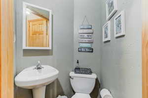 Bathroom featuring toilet and a textured wall